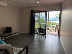 a living room with a view of a table and chairs at The Orchid Suite - Apartment in Cooktown in Cooktown