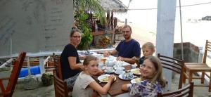 a group of people sitting at a table eating food at Gems Garden Guest House in Tangalle