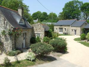 an old stone house with a driveway at Le Clos De Lascoer in Plumergat