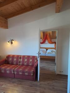 ein Wohnzimmer mit einem Sofa und einem Bett in der Unterkunft Appartementhaus Chalet Alpina in Sankt Johann in Tirol