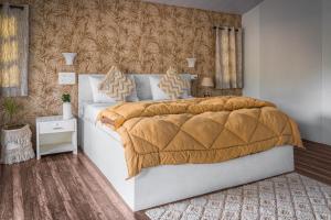 1 dormitorio con 1 cama grande con manta marrón en Cuba Patnem, en Patnem