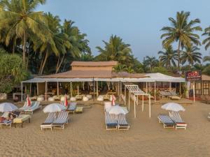a group of chairs and umbrellas on a beach at Cuba Patnem in Patnem