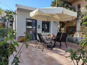 a patio with a table and an umbrella at Irini's Home - Pitsidia in Pitsidia