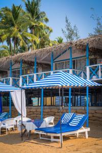 阿貢達的住宿－阿貢達庫巴住宿加早餐旅館，海滩上的一组椅子和遮阳伞