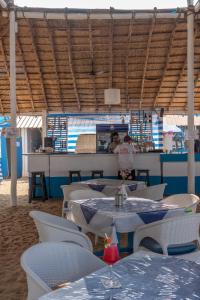 a restaurant with white tables and chairs and a counter at Cuba Agonda in Agonda