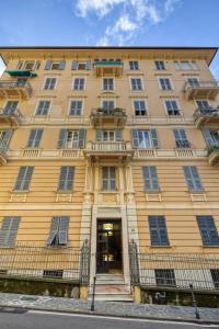 un grande edificio giallo con porta e scale di Livin' Portofino LUX a Santa Margherita Ligure