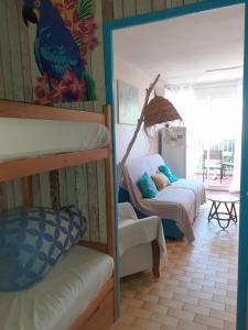 a room with two bunk beds and a table at Studio 4 pers, au calme, parking privé, wifi, linges fournis, 2 étoiles de France in La Grande Motte