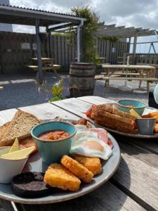 a plate of food with eggs and bread on a table at Wheal Tor- Beautifully Fitted Wooden Lodge Helston Cornwall in Helston