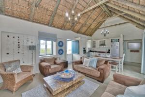a living room with a couch and chairs and a table at Zuidste Huisie Fisherman's Cottage in Struisbaai