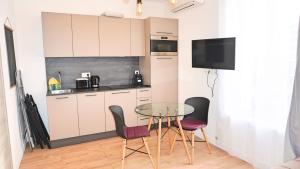 een kleine keuken met een glazen tafel en stoelen bij Centre Cannes, Appartement 301, 1 room By Palmazur in Cannes