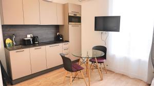 een kleine keuken met een tafel en stoelen in een kamer bij Centre Cannes, Appartement 301, 1 room By Palmazur in Cannes