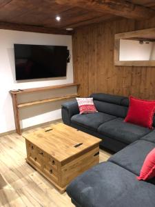 ein Wohnzimmer mit einem Sofa und einem TV in der Unterkunft Chalet 3 Céline 6 personnes Vieux Village in Bonneval-sur-Arc