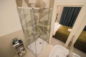 a bathroom with a shower with a toilet and a bed at Brettia Guest Rooms in Cosenza