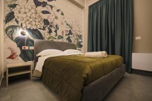 a bedroom with a bed and a floral wall at Brettia Guest Rooms in Cosenza