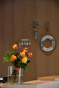 リニャーノ・サッビアドーロにあるAparthotel Alessandriaのテーブルの上にオレンジ色のバラが詰まった花瓶