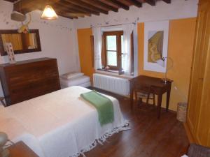 een slaapkamer met een bed, een bureau en een raam bij Podere Pian di Cava in Castelnuovo di Val di Cecina
