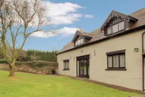 a white house with a tree in the yard at Stable Cottage in Ross on Wye