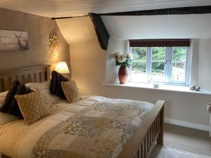 a bedroom with a large bed and a window at The Snuggery a Cosy Country Cottage in Wellington