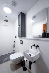 La salle de bains blanche est pourvue d'un lavabo et de toilettes. dans l'établissement Free Parking - Roof Terrace - Luxury Townhouse, à Manchester