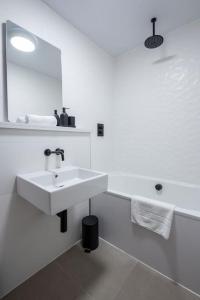 La salle de bains blanche est pourvue d'un lavabo et d'un miroir. dans l'établissement Free Parking - Roof Terrace - Luxury Townhouse, à Manchester