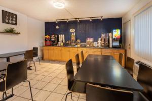 un restaurante con mesa, sillas y barra en Super 8 by Wyndham Wooster, en Wooster