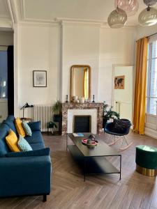 a living room with a blue couch and a fireplace at Sur les toits de Nîmes in Nîmes