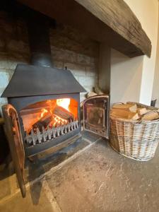 un horno de ladrillo con un fuego dentro de él en The Long Barn, en Baltonsborough