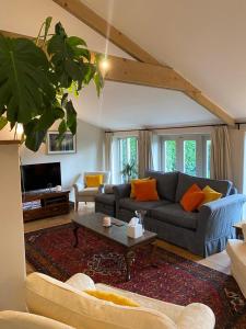 a living room with a couch and a table at The Long Barn in Baltonsborough