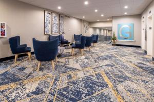 uma sala de espera com cadeiras azuis no chão em Baymont by Wyndham White Plains - Elmsford em Elmsford