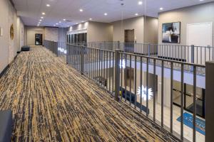 a large lobby with a pool and a carpet at Baymont by Wyndham White Plains - Elmsford in Elmsford