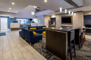 a lobby with blue chairs and a bar in a building at Baymont by Wyndham White Plains - Elmsford in Elmsford