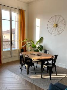 a dining room with a wooden table and chairs at Sur les toits de Nîmes in Nîmes