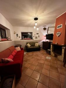 a living room with a red couch and a fireplace at Flamignano relax e natura in Tossicia