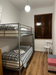 a bedroom with two bunk beds and a chair at Flamignano relax e natura in Tossicia