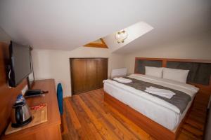 a bedroom with a large bed and a flat screen tv at AHISKA PALAS OTEL in Kars