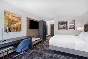 a hotel room with a bed and a desk at La Quinta Inn & Suites by Wyndham South Bend near Notre Dame in South Bend