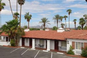un motel avec des palmiers en arrière-plan dans l'établissement Coronado Motor Hotel, a Travelodge by Wyndham, à Yuma