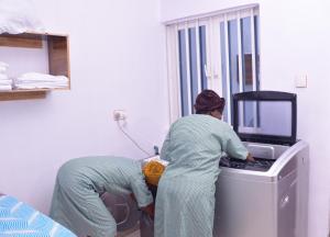 dwie kobiety pracujące przy komputerze w pokoju w obiekcie Akure Airport Hotel w mieście Oba Ile