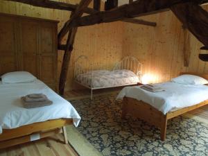 two beds in a room with wooden walls at Chai Gascon in Termes-dʼArmagnac