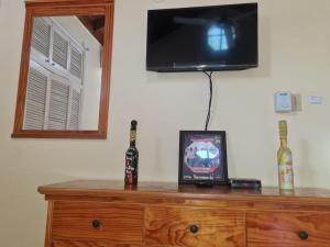 a wooden dresser with a television on top of it at Dancehall Hostel in Kingston