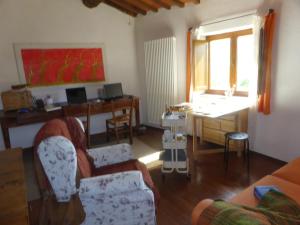 ein Wohnzimmer mit einem Sofa und einem Schreibtisch in der Unterkunft Podere Pian di Cava in Castelnuovo di Val di Cecina