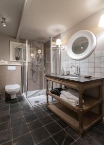 a bathroom with a shower and a sink and a toilet at von-Deska-Countryhouses-Offiziers-Apartment in Nieblum