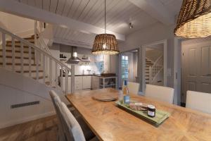 a kitchen and dining room with a wooden table and chairs at von-Deska-Countryhouses-Reeder-Fluegel in Nieblum +10 photos