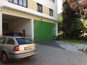 a car parked in front of a building with green doors at Gadenstätter Apartments in der City in Zell am See