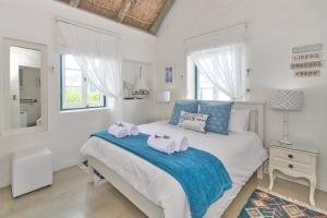 1 dormitorio con 1 cama con toallas en Zuidste Huisie Fisherman's Cottage, en Struisbaai