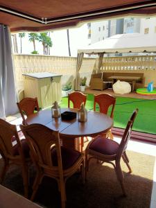 eine Terrasse mit einem Tisch und Stühlen sowie einem Spielplatz in der Unterkunft EL DESCANSO in Calpe