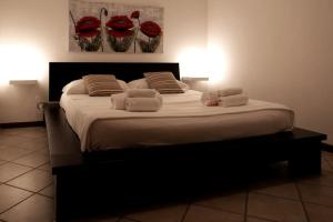 a large bed with white pillows and red flowers on it at Esperanto Suite&Pool - Nuova Gestione 2026 in Favignana