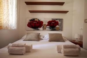a bedroom with a bed with two red flowers on it at Esperanto Suite&Pool - Nuova Gestione 2026 in Favignana