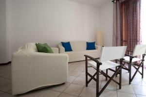 - un salon avec un canapé blanc et des chaises dans l'établissement Esperanto Suite&Pool, à Favignana