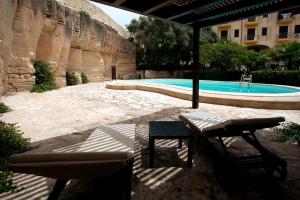 un patio con sedia, ombrellone e piscina di Esperanto Suite&Pool a Favignana